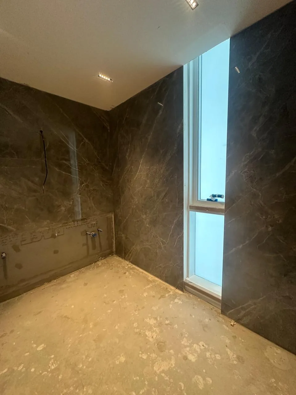 Baño revestido con placas oscuras de gran formato