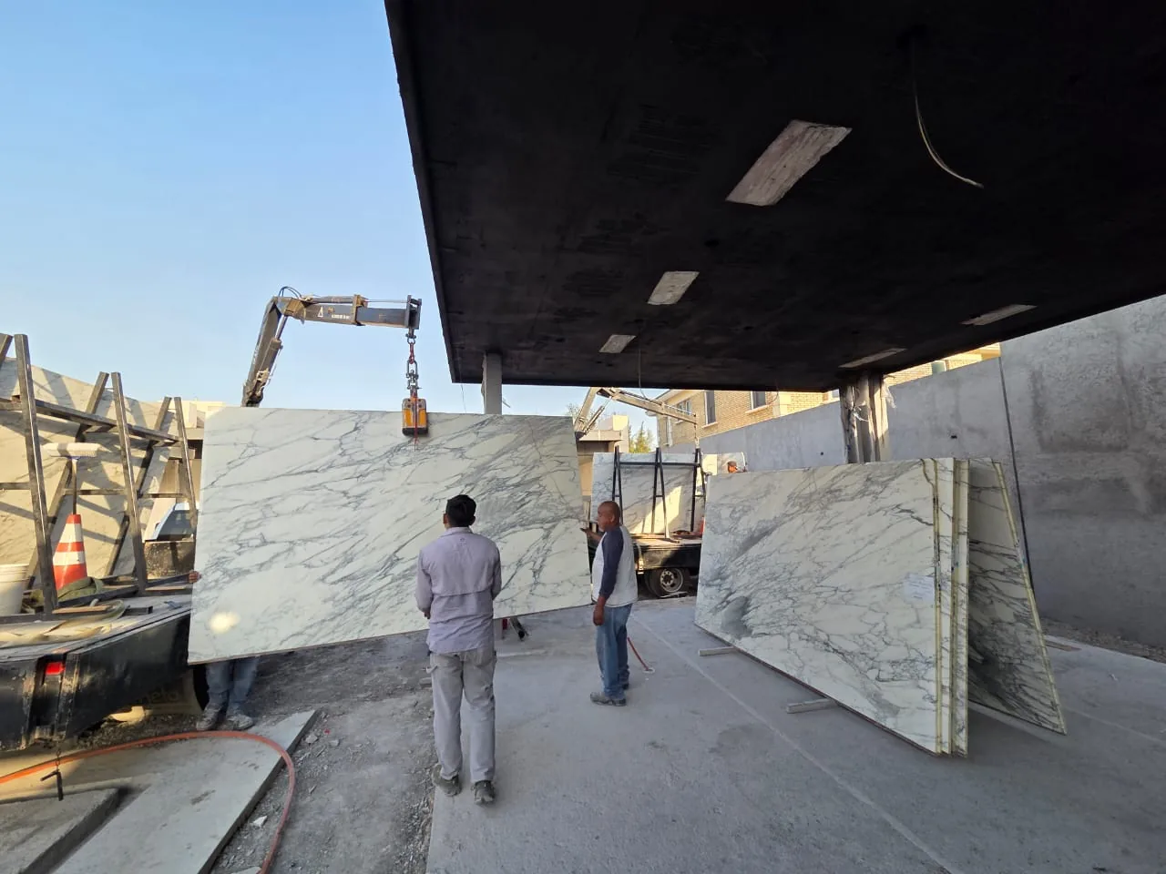 Equipo recibiendo placas de piedra de gran formato en obra